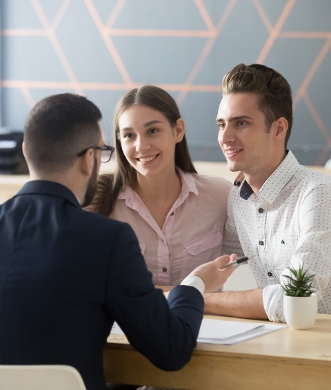 Male agent talks to young couple